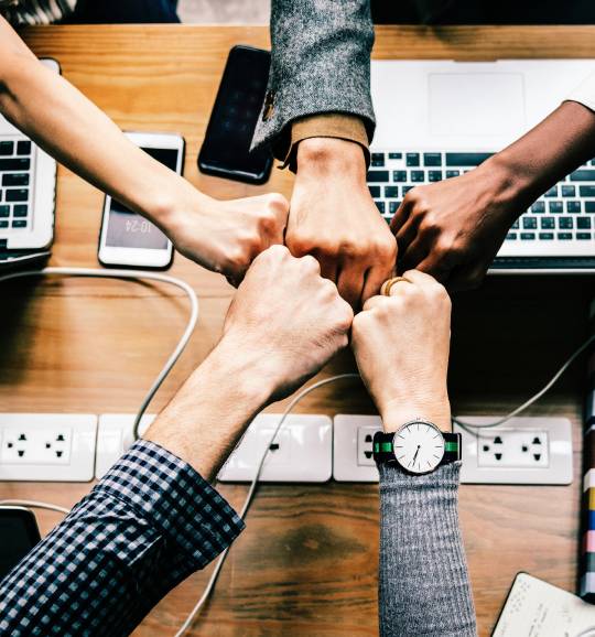 Hands fist bumping over planning table
